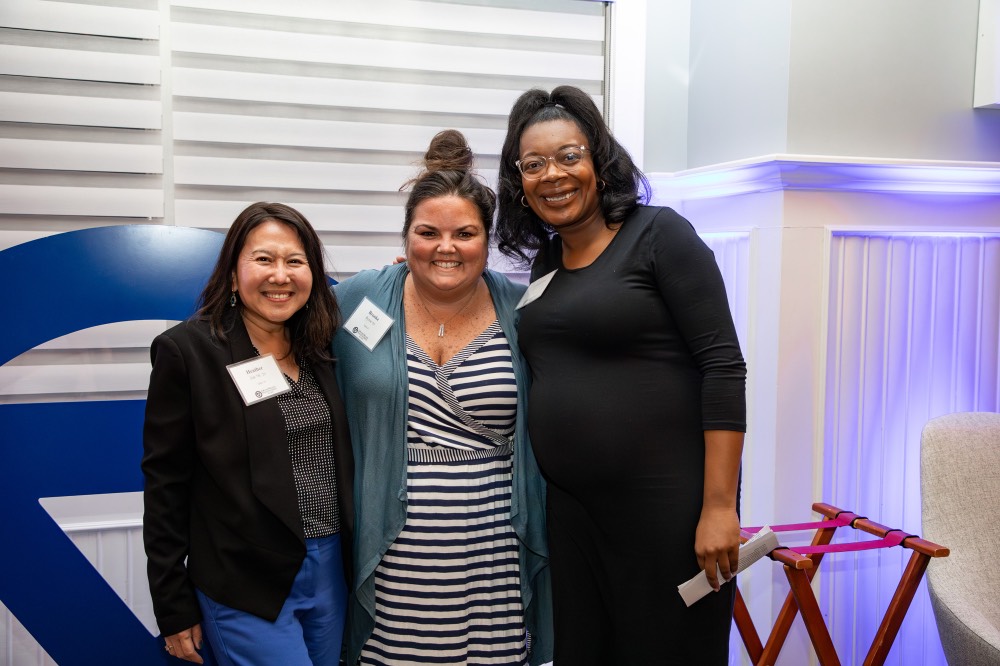 3 women pose together in the Alumni House